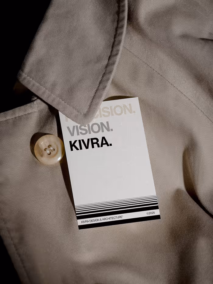 White tag reading 'VISION. KIVRA.' attached to beige fabric near a button.